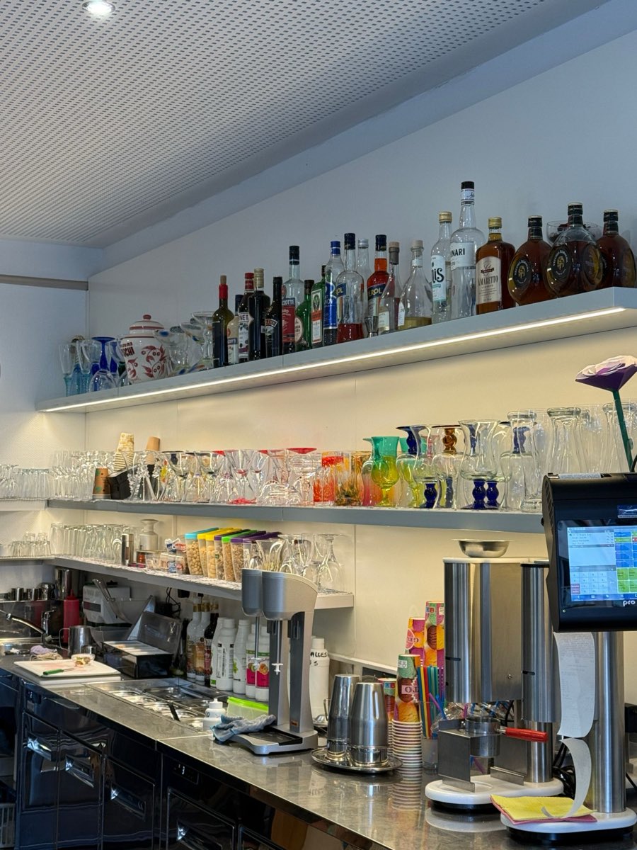 Arbeitsbereich hinter der Theke mit Eisbechergläsern, Mixer und Zutaten