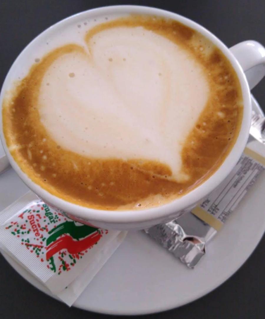 Cappuccino mit einem Herz aus Milchschaum auf weißer Tasse
