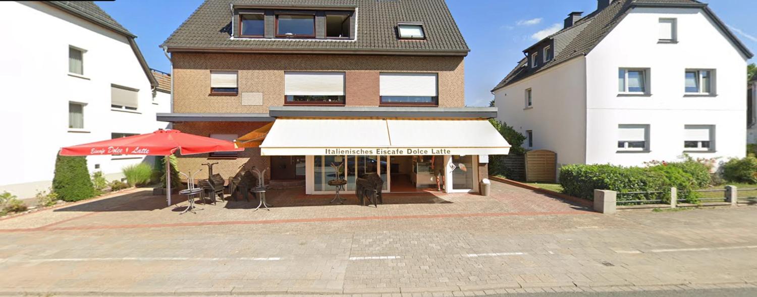Das Eiscafé Dolce Latte in Osnabrück-Lüstringen mit Markise, rotem Sonnenschirm und Terrasse