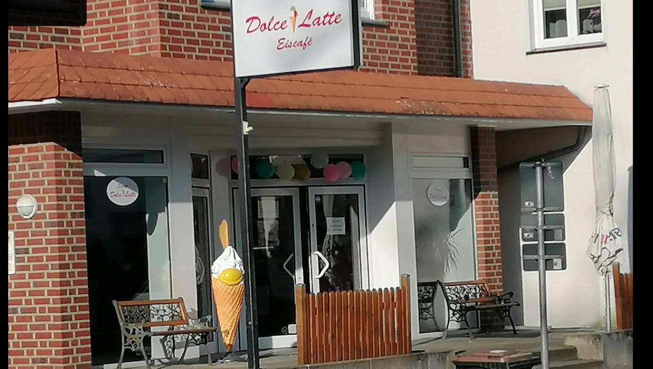 Eingang des Eiscafés in Schledehausen mit großer Eistüte, Bänken und Luftballons